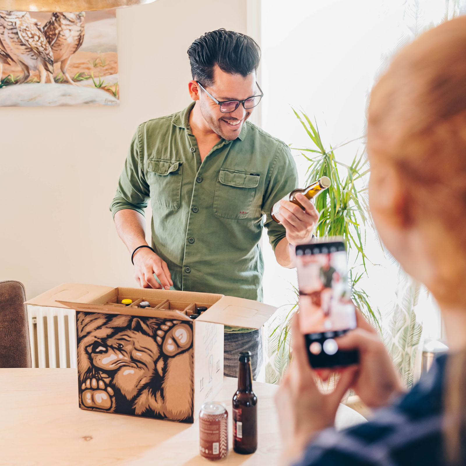 Collega's die samen een borrelbox uitpakken en proosten